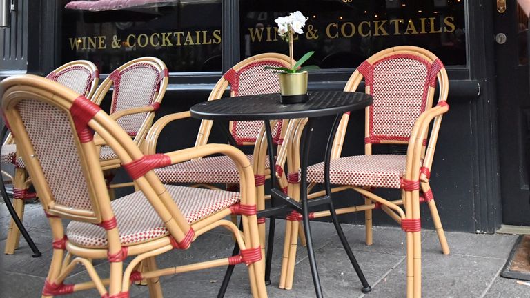 A bartender wearing a face mask stands outside a bar in Cardiff ahead of pubs, bars, restaurants and cafes being forced to stop selling alcohol and shut by 6pm as part of a new round of coronavirus restrictions that come into force in Wales on Friday night.