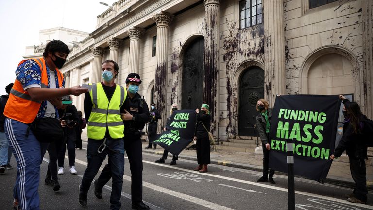 A police officer detains an activist from the Extinction Rebellion, a global environmental movement, during a protest outside the Bank of England building, in London, Britain, April 1, 2021. REUTERS/Henry Nicholls
