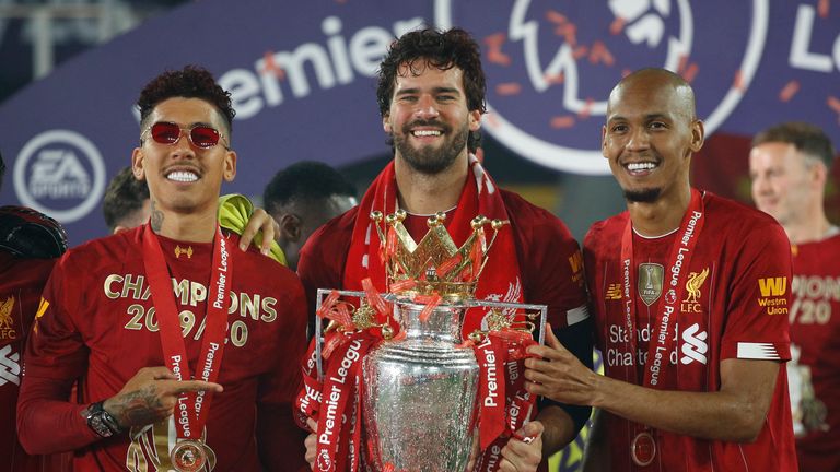 Liverpool's Alisson, Roberto Firmino and Fabinho (right) celebrate with the trophy after winning the Premier League