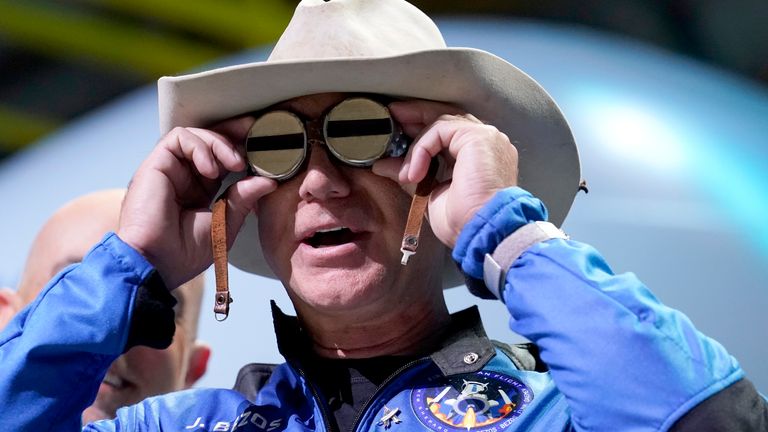 Jeff Bezos puts goggles over his eyes that belonged to aviator Amelia Mary Earhart during a post-launch news briefing. Pic: AP