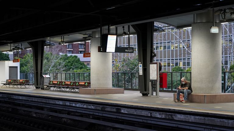 A lone passenger in protective face mask waits at the quiet Circular Quay train station during a lockdown to curb the spread of a coronavirus disease (COVID-19) outbreak in Sydney, Australia, July 28, 2021. REUTERS/Loren Elliott