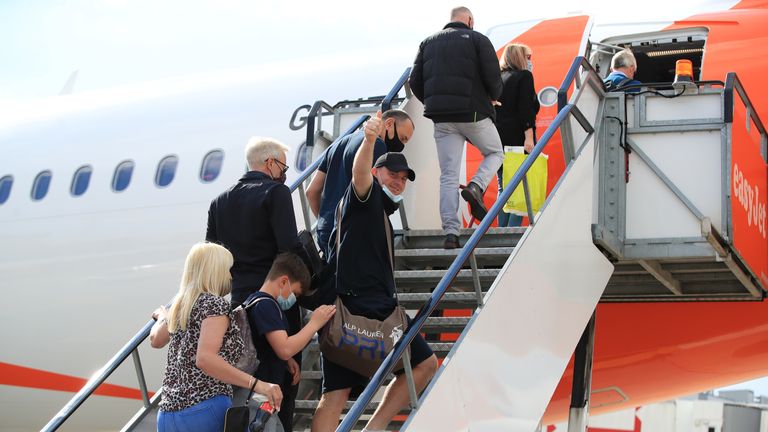 Passengers prepare to board an easyJet flight to Faro, Portugal, at Gatwick Airport