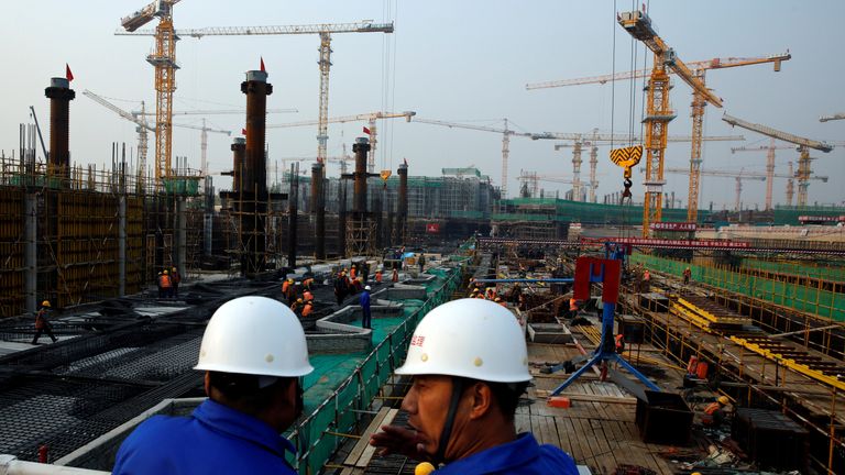 FILE PHOTO: Workers survey the construction site of the terminal for the Beijing New Airport in Beijing's southern Daxing District, China October 10, 2016. 