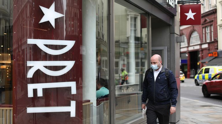 A man wearing a face mask as a precaution against the spread of the novel coronavirus walks past a Pret a Manger store in central London on August 28, 2020. - British coffee and sandwich chain Pret a Manger on August 27 said it was cutting 2,800 jobs as a result of the impact of the coronavirus outbreak. 