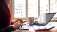 File photo dated 04/03/20 of a woman using a laptop on a dining room table set up as a remote office to work from home. 