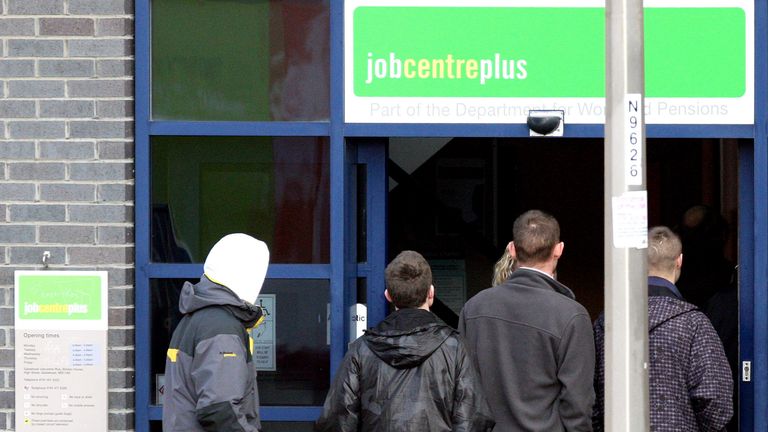 Men queue outside of a Job Centre