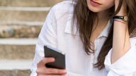 Unhappy woman texting sitting at the stairs

