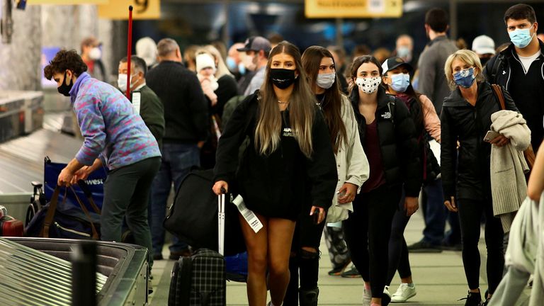 Travellers wearing protective face masks to prevent the spread of the coronavirus disease (COVID-19) reclaim their luggage at the airport in Denver, Colorado, U.S., November 24, 2020