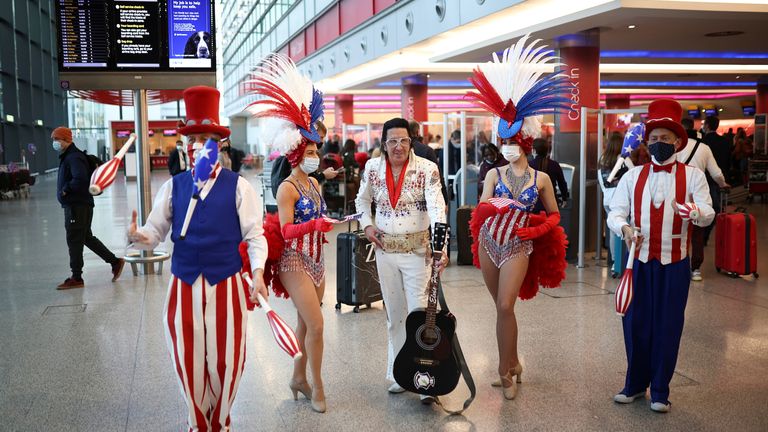 Performers engage with travellers as they queue to check into Virgin Atlantic and Delta Air Lines flights at Heathrow Airport Terminal 3, following the lifting of restrictions on the entry of non-U.S. citizens to the United States imposed to curb the spread of the coronavirus disease (COVID-19), in London, Britain, November 8, 2021. REUTERS/Henry Nicholls
