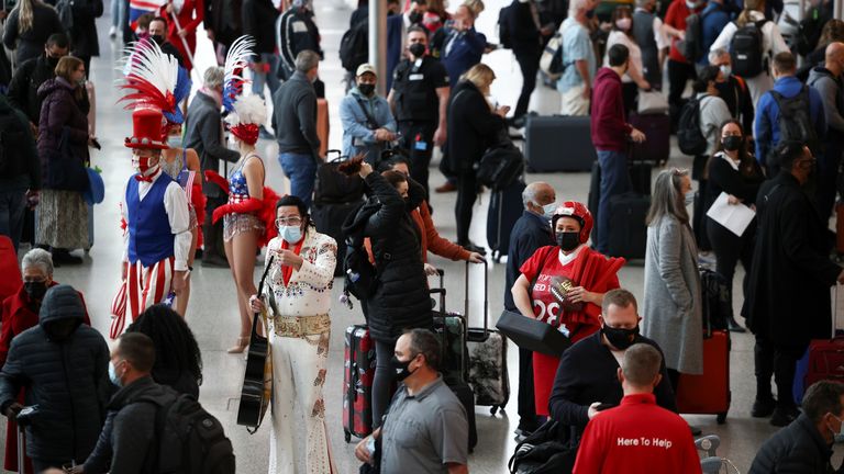 Performers engage with travellers as they queue to check into Virgin Atlantic and Delta Air Lines flights at Heathrow Airport Terminal 3, following the lifting of restrictions on the entry of non-U.S. citizens to the United States imposed to curb the spread of the coronavirus disease (COVID-19), in London, Britain, November 8, 2021. REUTERS/Henry Nicholls
