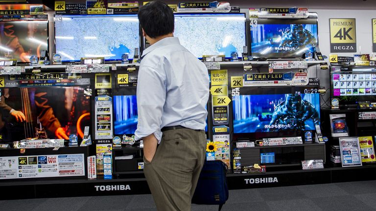 A man looks at TVs of Toshiba Corp at an electronics store in Tokyo July 21, 2015