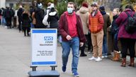 A man walks next to a queue of people waiting to receive COVID-19 vaccine and booster doses, as the spread of the coronavirus disease (COVID-19) continues, at a walk-in vaccination centre at Saint Thomas' Hospital in London, Britain, December 14, 2021. REUTERS/Toby Melville
