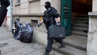 Police leaves a building during raids in several locations in Dresden, Germany, December 15, 2021, as part of an investigation into what they said was a plot to murder the state's prime minister, Michael Kretschmer, by anti-vaccination activists. The searches in the city of Dresden targeted individual members of a group on the messaging program Telegram, where plans for the killing were discussed in connection with the state government's coronavirus curbs, police said.  