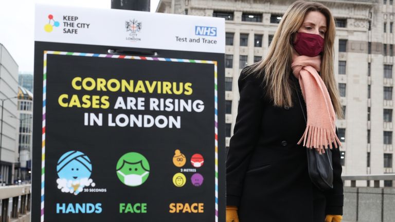 File photo of a woman walking past a coronavirus information sign on London Bridge. A greater proportion of black and Asian people are dying with coronavirus than white people, despite case numbers in the latter group being higher, a study has warned.