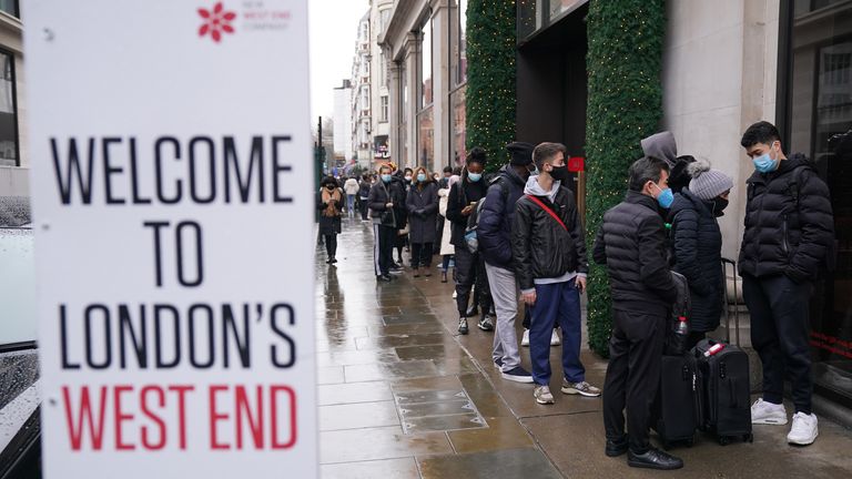 Shoppers stand in line for the doors to open for the start of the Boxing Day sales at Selfridges department store on Oxford Street in London. Consumers are set to shop from home but spend more in the post-Christmas sales than in previous years in a reassuring sign for online retailers, a survey suggests. Picture date: Sunday December 26, 2021.
