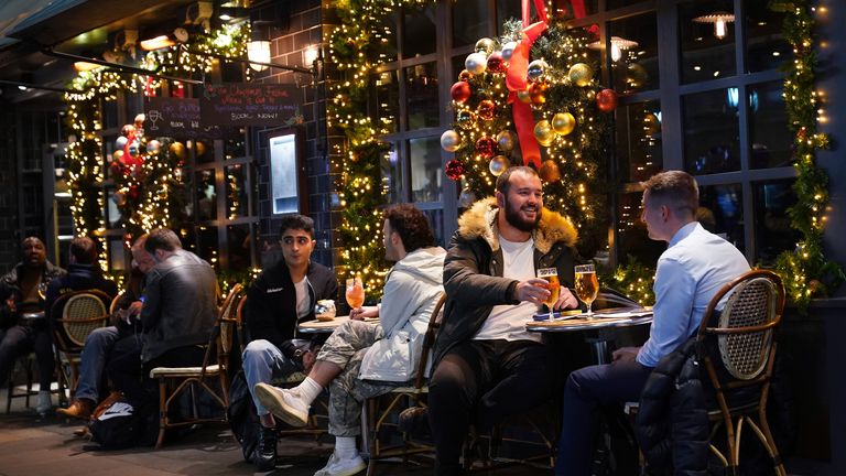 People drinking outside a bar in Soho, London, where new restrictions have come into force to slow the spread of the Omicron variant of coronavirus. Picture date: Wednesday December 15, 2021.
