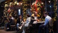 People drinking outside a bar in Soho, London, where new restrictions have come into force to slow the spread of the Omicron variant of coronavirus. Picture date: Wednesday December 15, 2021.
