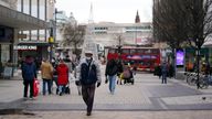 People wearing face masks walk along High Street in Birmingham