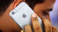 A man talks on his iPhone at a mobile phone store in New Delhi, India, July 27, 2016