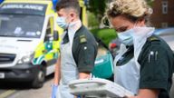 PORTSMOUTH, ENGLAND - MAY 05: An ambulance crew from the South Central Ambulance Service wear protective clothing as they complete the digital paperwork after responding to a false alarm call for a heart attack on May 05, 2020 in Portsmouth, England. Due to the risk of contamination to the air ambulance helicopters, patients have been transferred to the mainland using the hovercraft service since the beginning of May. As the list of recognised Covid-19 symptoms grows, paramedic crews like those with the South Central Ambulance Service are forced to treat every patient as being a potential case, often requiring specialised personal protective equipment (PPE). Paramedics now routinely don what the NHS refers to as Level 2 PPE, like face masks and disposable aprons. Cases with patients potentially needing airway procedures require Level 3 PPE, such as full-face visors and long-sleeved surgical gowns. While the infection rate is falling, and government officials are discussing ways to relax the country's quarantine measures, Covid-19 still creates everyday risks for paramedics and other first responders. (Photo by Leon Neal - Pool/Getty Images)