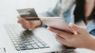 Woman hands holding a credit card and using smart phone for online shopping. Online payment concept