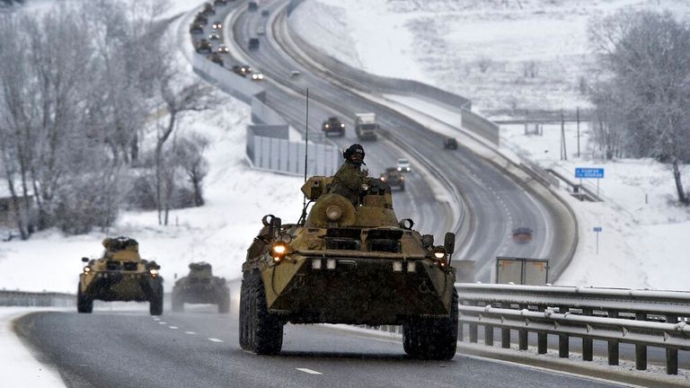 A convoy of Russian armored vehicles moves along a highway in Crimea