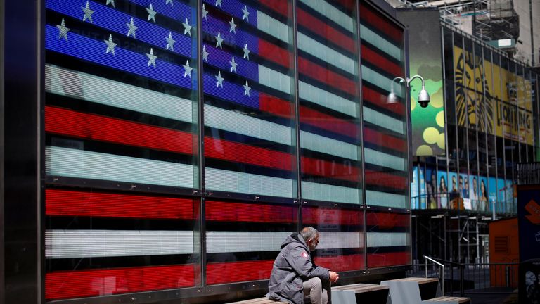 A homeless man sits alone in a nearly empty Times Square in Manhattan during the outbreak of the coronavirus disease (COVID-19) in New York City, New York, U.S., April 7, 2020