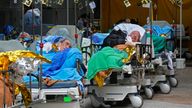 Patients lie in gurneys waiting for hospital treatment. Pic: AP

