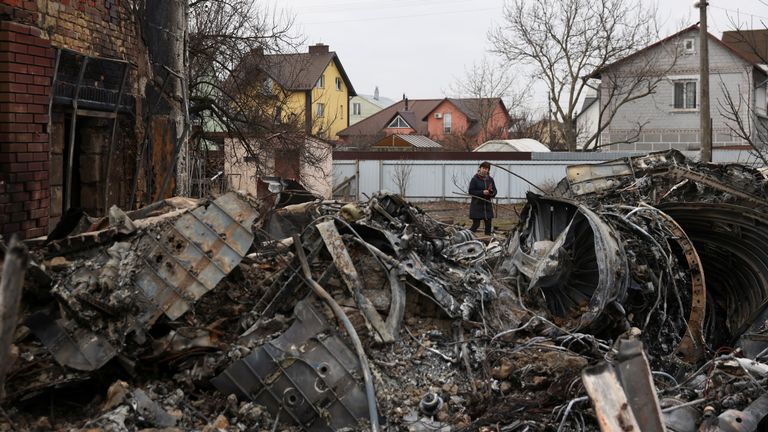 A woman walks around the wreckage of an unidentified aircraft that crashed into a house in a residential area, after Russia launched a massive military operation against Ukraine, in Kyiv, Ukraine February 25, 2022. REUTERS/Umit Bektas
