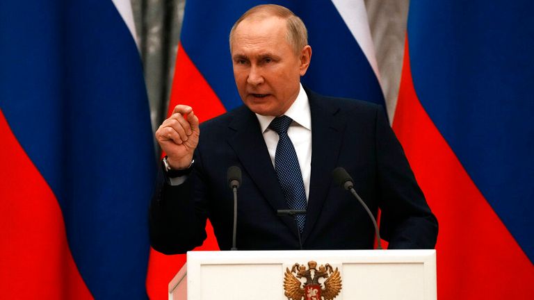 Russian President Vladimir Putin gestures during a joint press conference with French President Emmanuel Macron