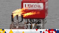 FILE PHOTO: A gas torch is seen next to the Lukoil company sign at the Filanovskogo oil platform in the Caspian Sea, Russia October 16, 2018.  REUTERS/Maxim Shemetov/File Photo