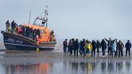 A group of people thought to be migrants are are guided up the beach after being brought in to Dungeness, Kent, onboard the RNLI Lifeboat following a small boat incident in the Channel. Picture date: Thursday March 24, 2022.