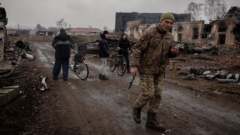 A woman walks past a burned out Russian vehicle left behind after Ukrainian forces expelled Moscow's troops from the the town of Trostyanets which they had occupied at the beginning of their war with Ukraine