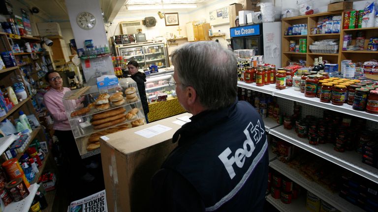 A FedEx driver delivers a package to a New York deli. Pic: AP