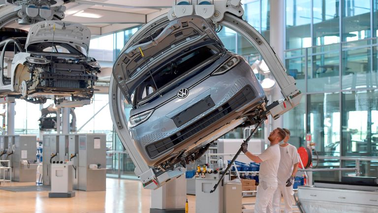 FILE PHOTO: Technicians work in the assembly line of German carmaker Volkswagen's electric ID. 3 car in Dresden, Germany, June 8, 2021. 