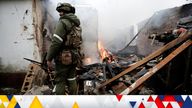 A serviceman of pro-Russian militia stands next to a house that caught fire after recent shelling, in the separatist-controlled city of Donetsk, Ukraine February 28, 2022. REUTERS/Alexander Ermochenko
