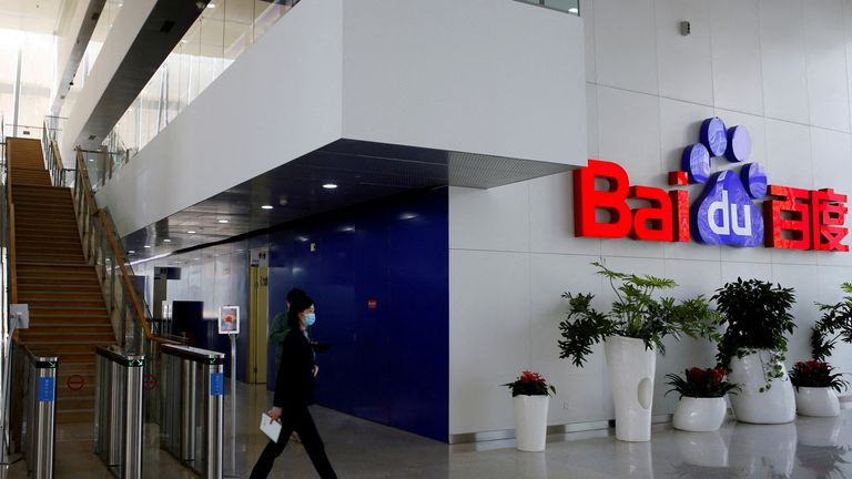 People walk near a Baidu logo at the company headquarters in Beijing, China April 23, 2021. REUTERS/Florence Lo//File Photo