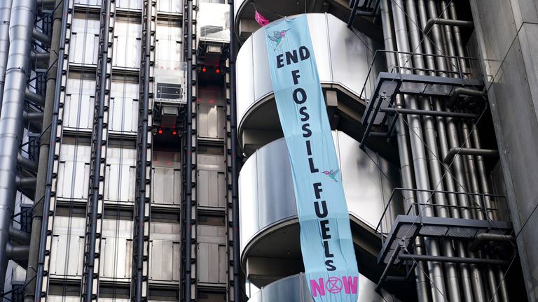 Activists from Extinction Rebellion unfurl a banner on the side of Lloyds of London, in the City of London. Picture date: Tuesday April 12, 2022.