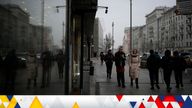 People walk past a currency exchange office screen displaying the exchange rates of U.S. Dollar and Euro to Russian Rubles in Moscow's downtown, Russia, Tuesday, March 29, 2022. (AP Photo)