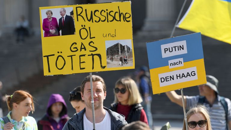 26 March 2022, Bavaria, Munich: Demonstrators with placards reading 