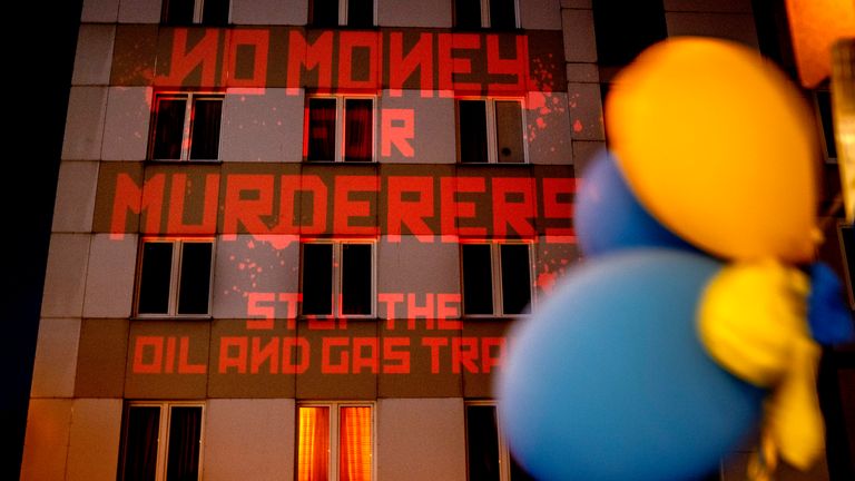 The words "No Money for Murderers, Stop the Oil and Gas Trade" are projected by activists onto the Russian consulate in Frankfurt, Germany, Monday, April 4, 2022. (AP Photo/Michael Probst)