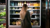 Woman buying food at the supermarket and reading a label on a product - lifestyle concepts 