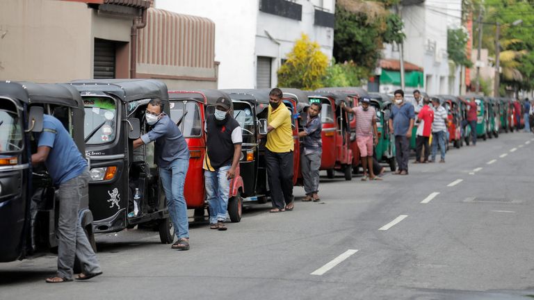 Drivers push their three-wheelers while waiting in a line to buy petrol at a Ceylon Ceypetco fuel station on a main road, amid the country's economic crisis in Colombo, Sri Lanka, April 12, 2022. REUTERS/Dinuka Liyanawatte
