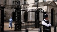 A police forensic official enters the Horse Guards building as a police officer stands guard at the cordoned-off area on Whitehall in Westminster after the road was closed by police following an incident involving the arrest of a man near Downing Street, in London, Britain, April 18, 2022. REUTERS/Henry Nicholls
