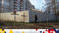 A man stands next to graves with bodies of civilians, who according to local residents were killed by Russian soldiers, as Russia's attack on Ukraine continues, in Bucha, in Kyiv region, Ukraine April 4, 2022.  REUTERS/Vladyslav Musiienko