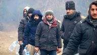 Asylum seekers collect drinking water as they endure freezing conditions. Pic: AP