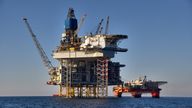 View of offshore oil and gas installation in a sunny day in sea. Jack up, semi submersible rigs crude oil production in ocean.

