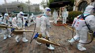 Volunteers in protective suits prepare to disinfect a residential compound in Huangpu district to tackle COVID outbreak in Shanghai