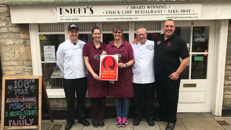George Knight and his family outside their fish and chip shop in Glastonbury. It's thought to be one of the oldest family-run chippies in the UK