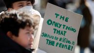 A person holds a sign during a protest about the rising cost of living during a demonstration outside Downing Street in London, Britain, April 2, 2022. REUTERS/Peter Nicholls